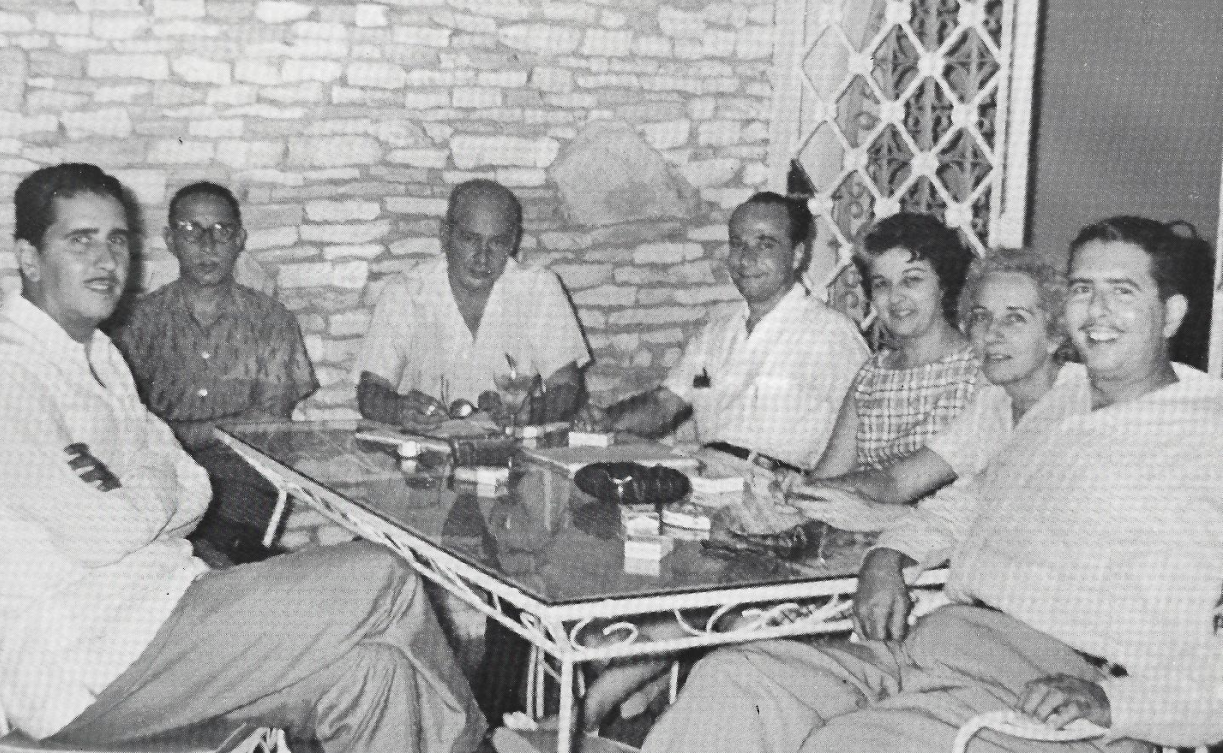 Reunión familiar de los Bonnelly Álvarez alrededor de una mesa de hierro forjado, finales de los años 1950